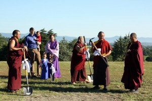 HE Dzigar Kongtrul Rinpoche and HE Jetsün Khandro Rinpoche prepare to break the ground at the designated time as Ven. Thrinley Gyaltsen checks his watch.