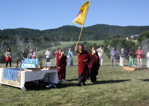 HE Dzigar Kongtrul Rinpoche waves the ceremonial banner, accompanied by sounds of conch shells and prayers of auspiciousness.