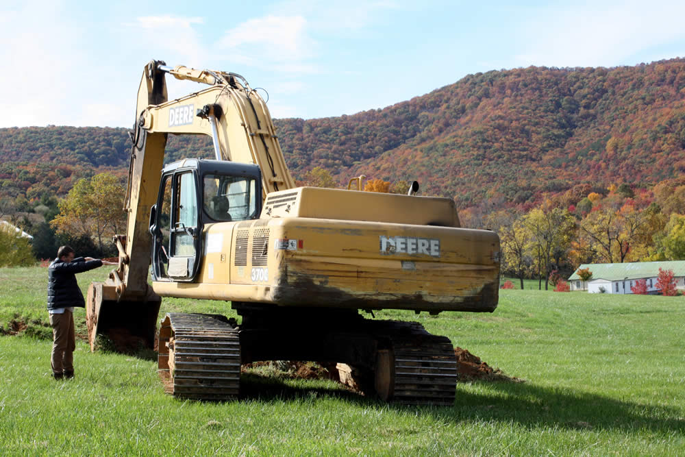 Kunda Britton Bosarge la, head of Exoansion and Development, talks with the driver of the track loader.