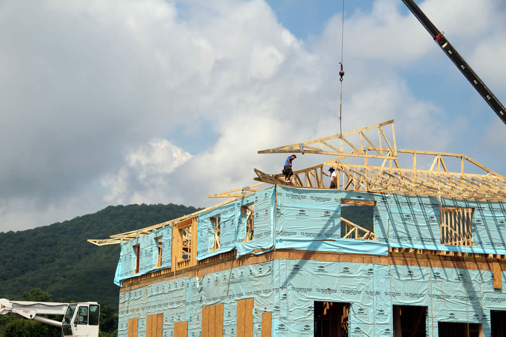 JULY 14-Workers installing hip tails on the roof at the easterb end of the temple.