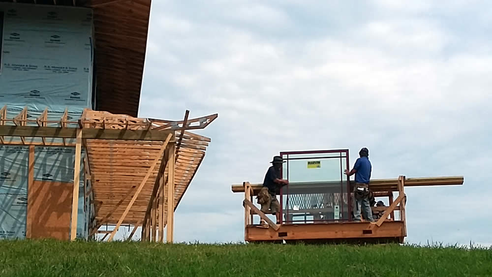AUGUST 1&mdash;Workers prepare to install a window.