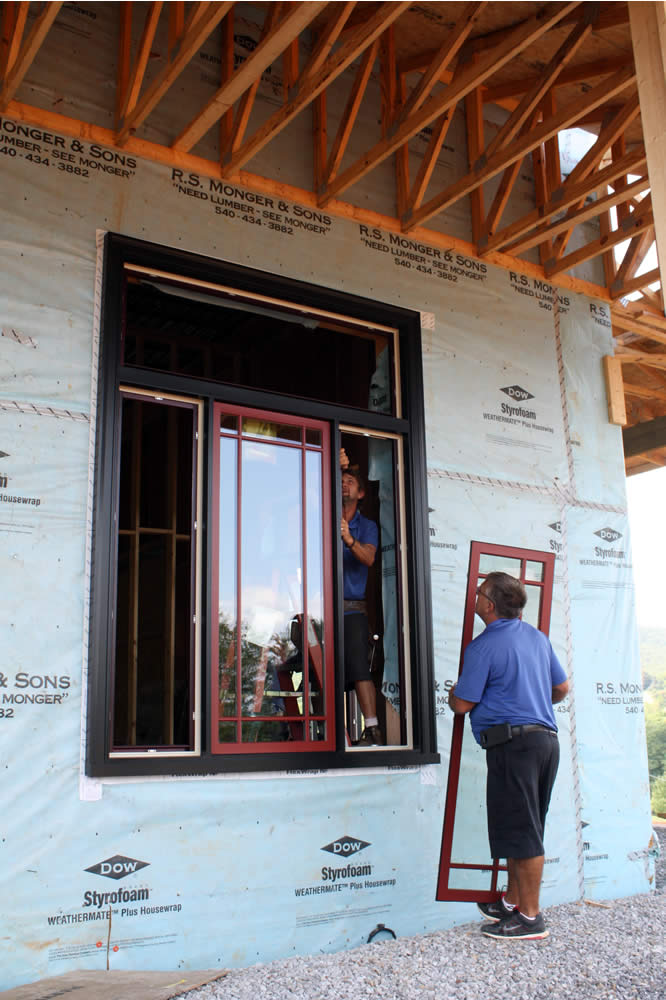 AUGUST 25-Workers install windows into frames. The transom at the top will provide more light and open to allow the circulation of fresh air.