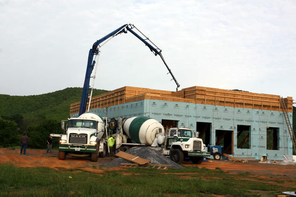 3 MAY—Cement mixer and pumper truck pour concrete for temple's second floor.