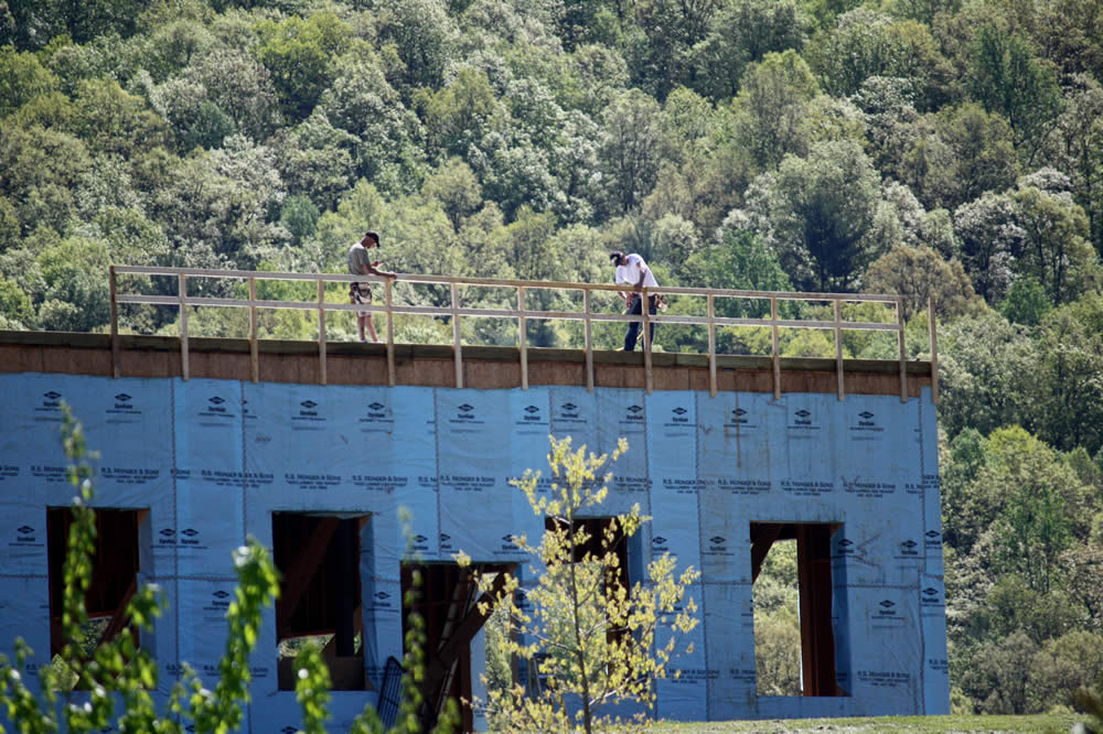 25 APRIL&mdash;Workers construct a safety/wind barrier in preparation for work on the second story of the temple.