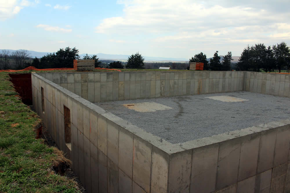 MARCH 25&mdash;The concrete having set sufficiently, the wall-forms are removed revealing the new foundation wall.
