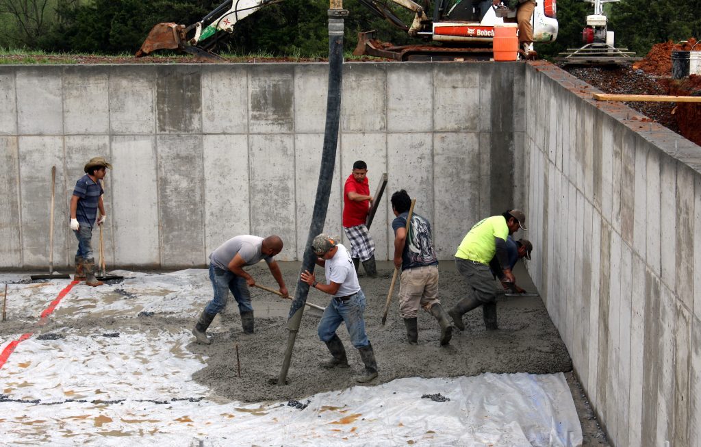 May 2-Workers applying the concrete from the hose and smoothing the surface.