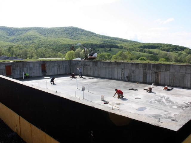 Once the concrete has dried sufficiently, workers check and touch up the surface of the new concrete floor.