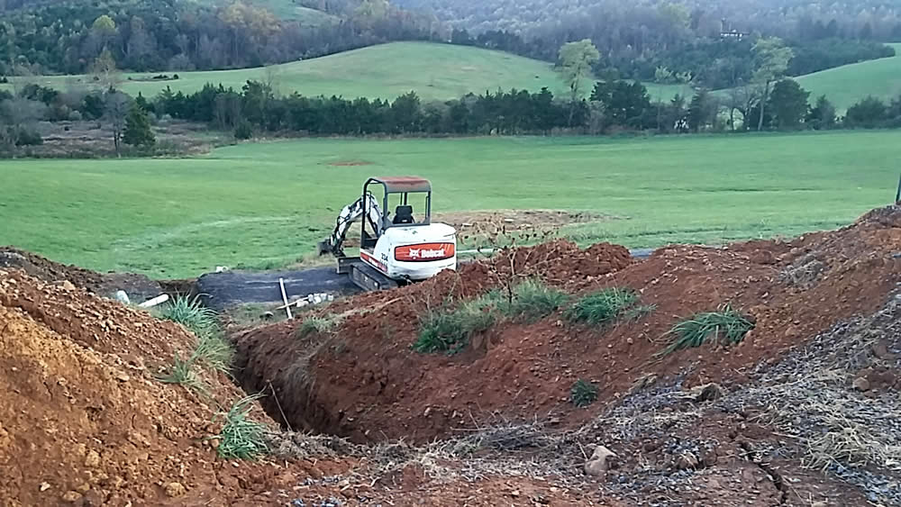NOVEMBER 16-Preparing to lay lines for the septic system. Septic field in the distance.