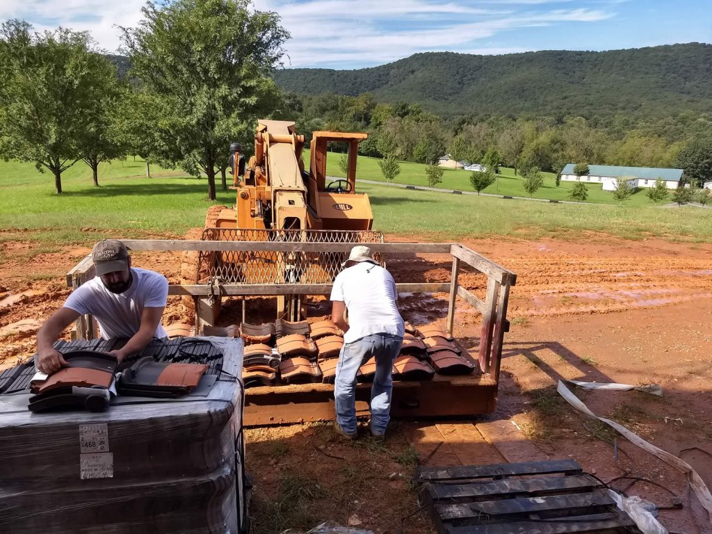 Roofers prepare to lift tiles.