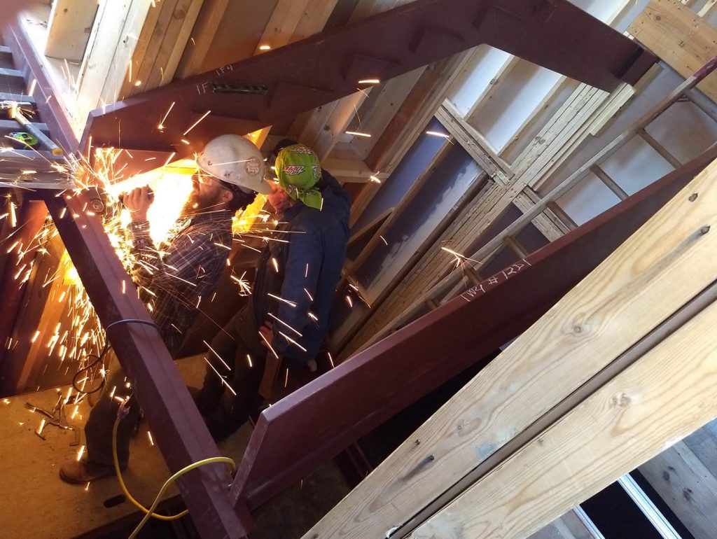Welders installing custom-fabricated stairways that meet OSHA regulations.