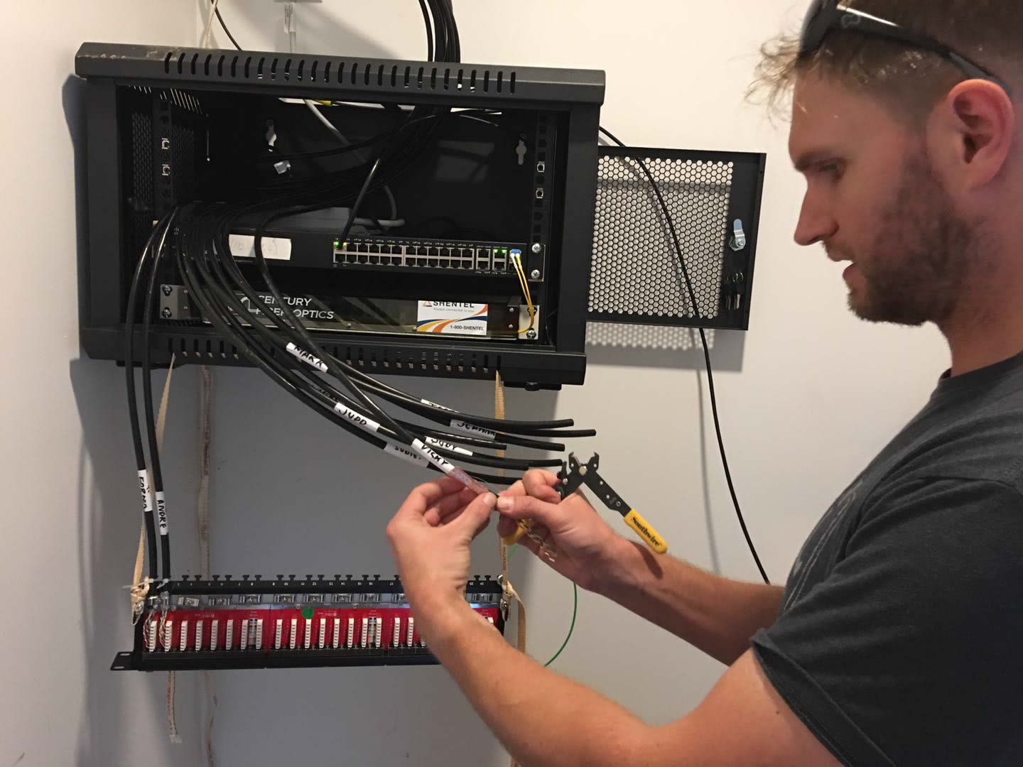 Alex Ryan prepares Cat6 cable in the network server rack.