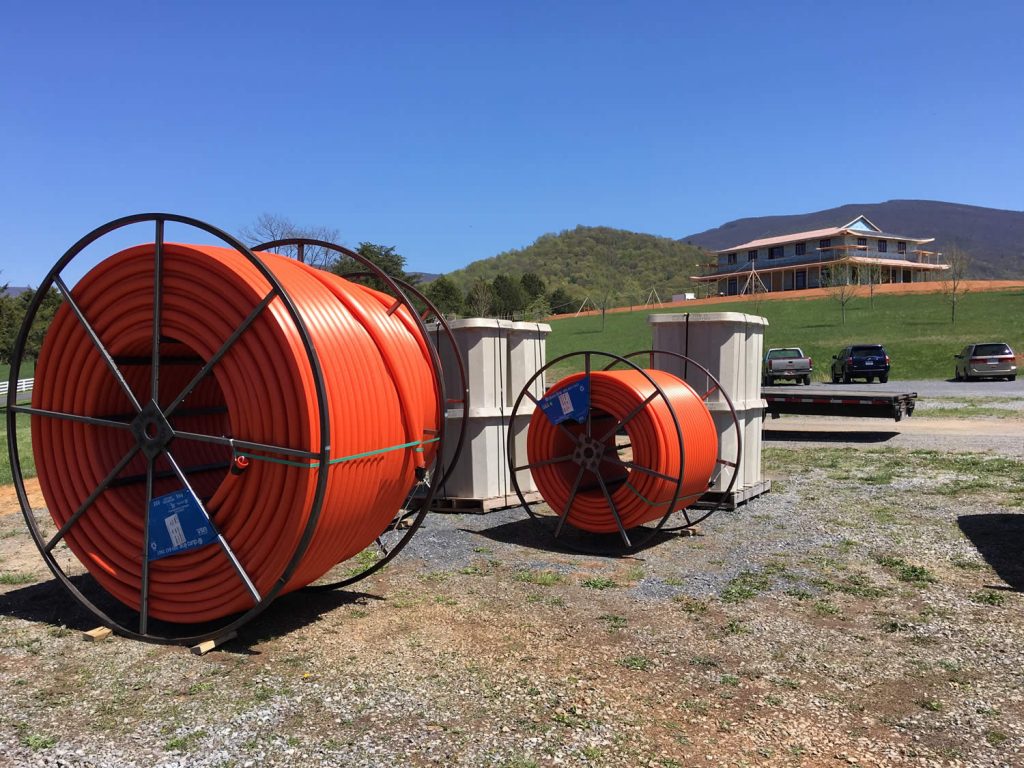 In early spring 2018, spools of conduit and handholes are delivered