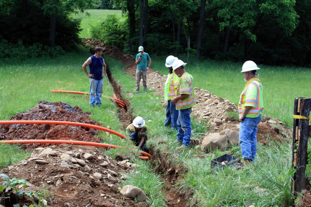 Alex Ryan and Dean Baker watch as Smartech team connects lengths of conduit.