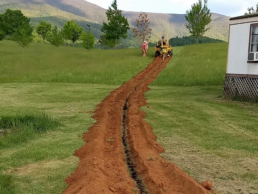 Roar Vestre, Alex Ryan and Dean Baker use the trencher (a.k.a. ditch witch)