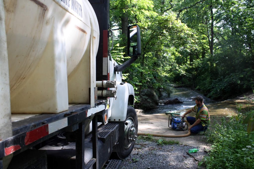 Filling the pump truck with water used to wash off the 'spoils' from the drill.